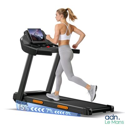 the woman is running on the tread machine with a laptop on it