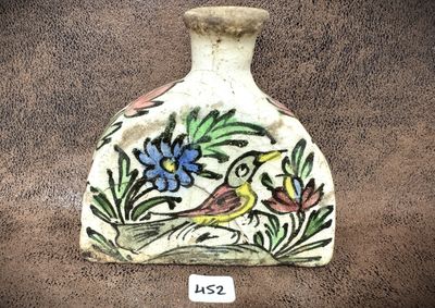 un petit vase sur lequel sont peints un oiseau et des fleurs