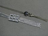 un bracelet en argent orné d'une perle noire et d'une chaîne en argent