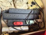 a box full of assorted items that include a remote control, a cell phone, and other items