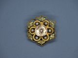 une image représentant une broche en or ornée de perles