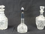 trois bouteilles en verre posées les unes à côté des autres sur un fond noir