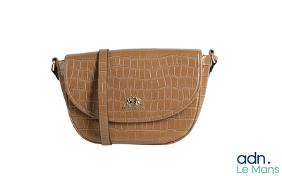 un sac à main marron posé sur une surface blanche