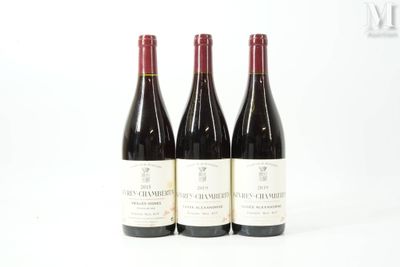 trois bouteilles de vin sont alignées sur une surface blanche