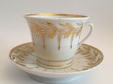 a cup and saucer on a saucer on a white table