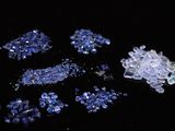 a pile of blue and white crystals on a black surface