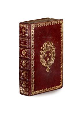 an old red book with gold trimming and ornate design