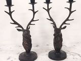 paire de bougeoirs en bronze en forme de tête de cerf, avec des bougies noires