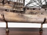 an image of a model of a ship on a wooden base