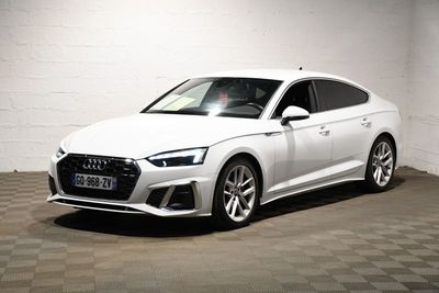 the white audi is parked in a garage with a checkered floor