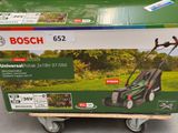 the box of a lawn mower is sitting on top of the cart