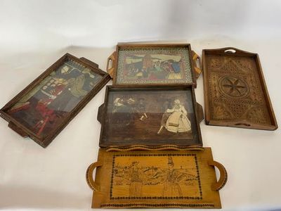 quatre plateaux en bois sur lesquels figurent des photos de personnes, posés sur une table