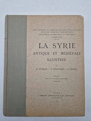 un vieux livre posé sur une table à côté d'un mur blanc