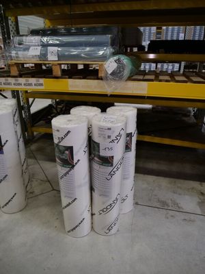 several rolls of paper are stacked on top of each other in a warehouse