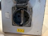a hand that is holding an electrical outlet on a table