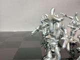 a chess board that has a bunch of silver figurines on it