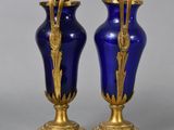 pair of blue and gold vases sitting on top of a table