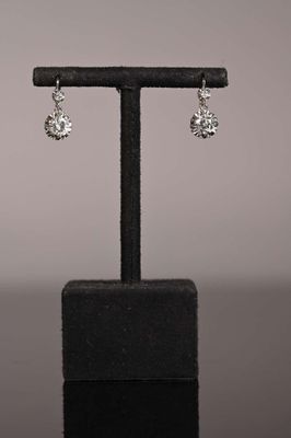 a close up of a pair of earrings on a stand