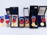 trois médailles et une médaille dans un cadre noir sur un fond blanc