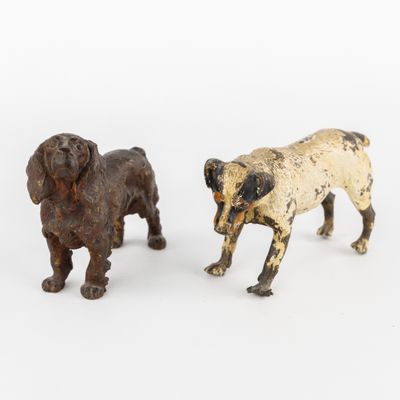 deux figurines de chiens sont placées l'une à côté de l'autre sur une surface blanche