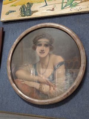 une photo d'une femme assise sur une chaise devant un tableau