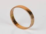 gros plan d'une bague en or sur une surface blanche