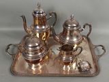 a silver tray with a silver tea set on it
