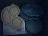 a lot of plastic plates and bowls in a box