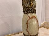a statue of an owl sitting on top of a marble table