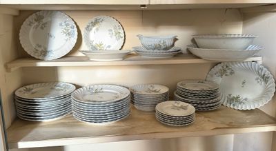 many plates and bowls on a shelf in the kitchen