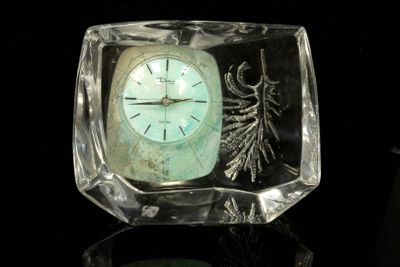 a glass clock sitting on top of a table
