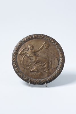 une image représentant une plaque en bronze sur laquelle figure une femme à cheval