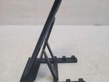 a black tablet computer sitting on a stand on a table