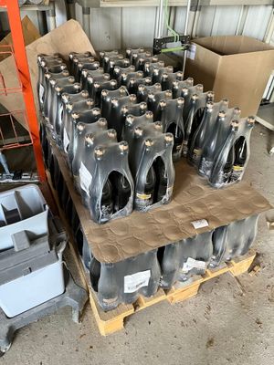 un gros tas de bouteilles en plastique noires posées sur une palette