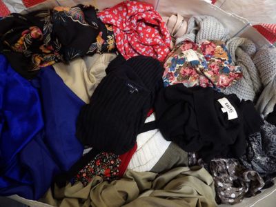 a suitcase full of clothes that is sitting on a bed