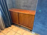 a wooden cabinet in the corner of a room