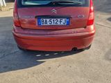 a picture of a red car parked in front of a garage
