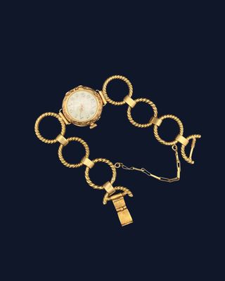 a gold bracelet with a watch and a key on it