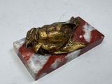 statue d'une tortue posée sur un bloc de marbre, sur une surface blanche