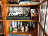 a book shelf with a lot of books and toys on it