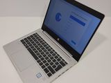 the laptop is open on a white surface with a blue screen