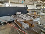 a machine that is cutting wood in a factory