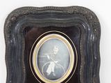 an old picture of a man riding a bicycle in a black frame
