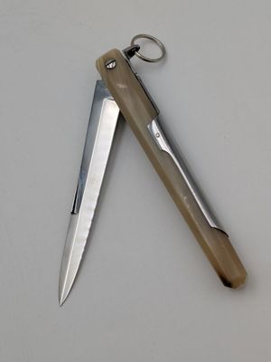 un couteau posé sur une table avec un porte-clés