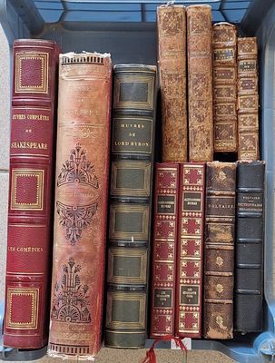 de nombreux livres anciens dans une boîte bleue posée sur une étagère