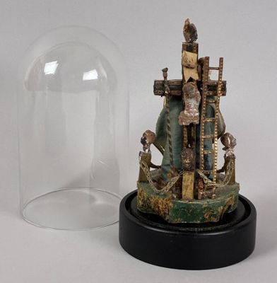 a statue of a man holding a cross under a glass dome