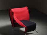 a red chair with a black seat in a dark room
