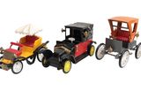 three toy cars sitting side by side on a white surface