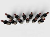 six bottles of wine lined up in a row on a white surface