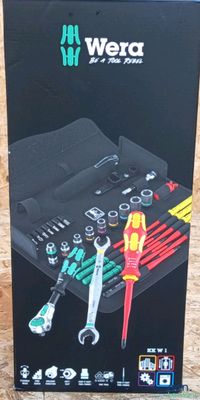 une boîte contenant des outils, posée sur un plancher en bois
